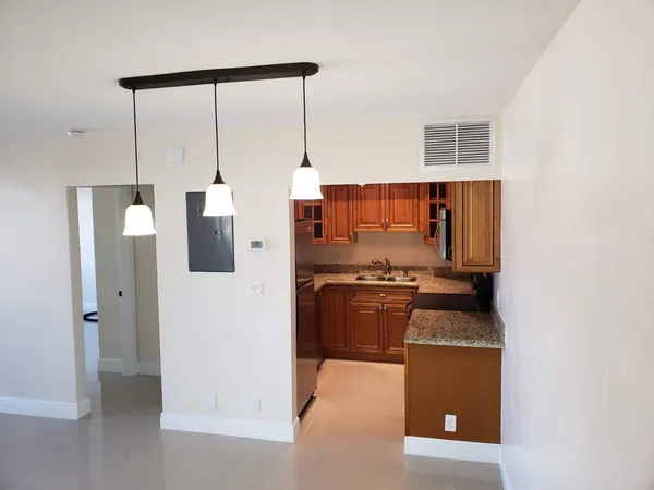 a bathroom with a granite countertop sink toilet and mirror
