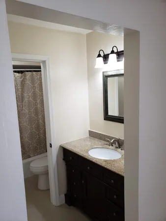 a bathroom with a granite countertop sink and a mirror
