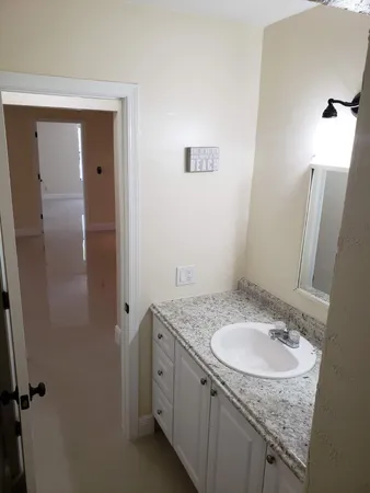 a bathroom with a granite countertop sink and a mirror