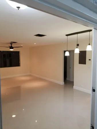 an empty room with a ceiling fan and window