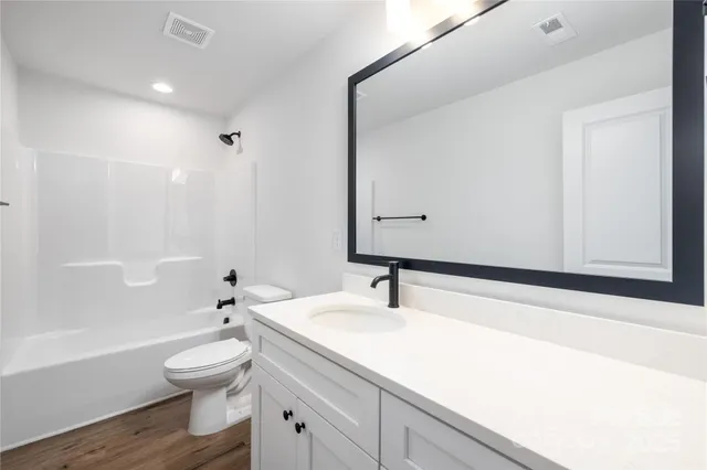 a bathroom with a sink a toilet and a large mirror