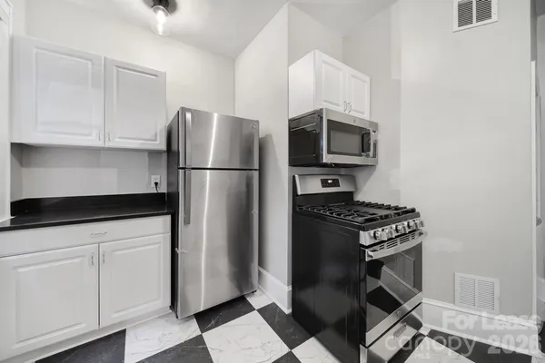 a kitchen with stainless steel appliances a refrigerator a stove a microwave and cabinets