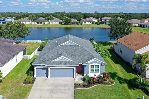 an aerial view of a house with a garden and lake view