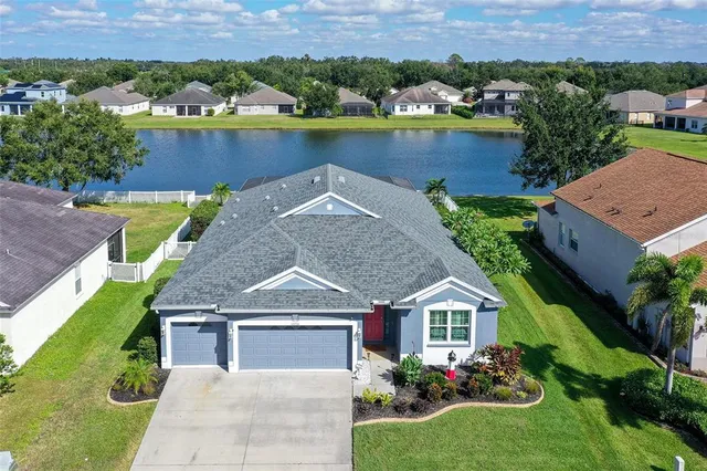 an aerial view of a house with a garden and lake view