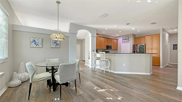 a kitchen with stainless steel appliances a refrigerator a stove a sink dishwasher with a dining table and chairs