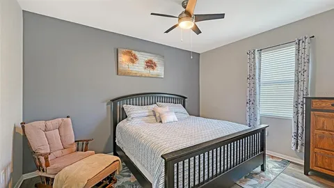 a bedroom with a bed and painting on the wall