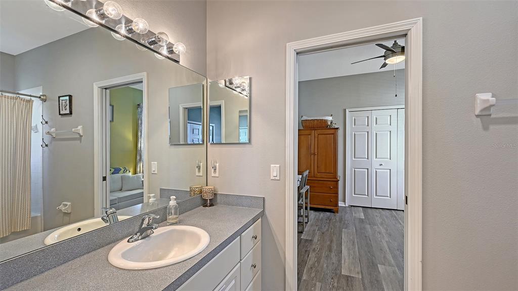 12274 23rd Street East Parrish, FL 34219 - Photo 27 of 64 a bathroom with a sink a mirror and a shower