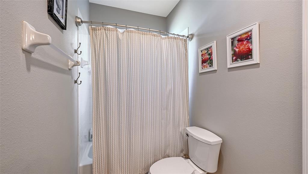 12274 23rd Street East Parrish, FL 34219 - Photo 28 of 64 a white toilet sitting next to a shower curtain
