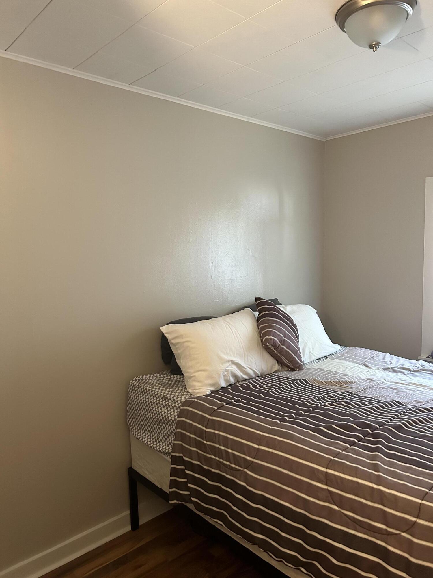 1038 Ridge Street Hammond, IN 46324 - Photo 11 of 31 a bedroom with a bed and a lamp on the dresser