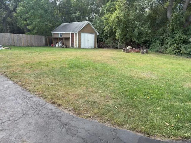 a house with yard and a trees in the background