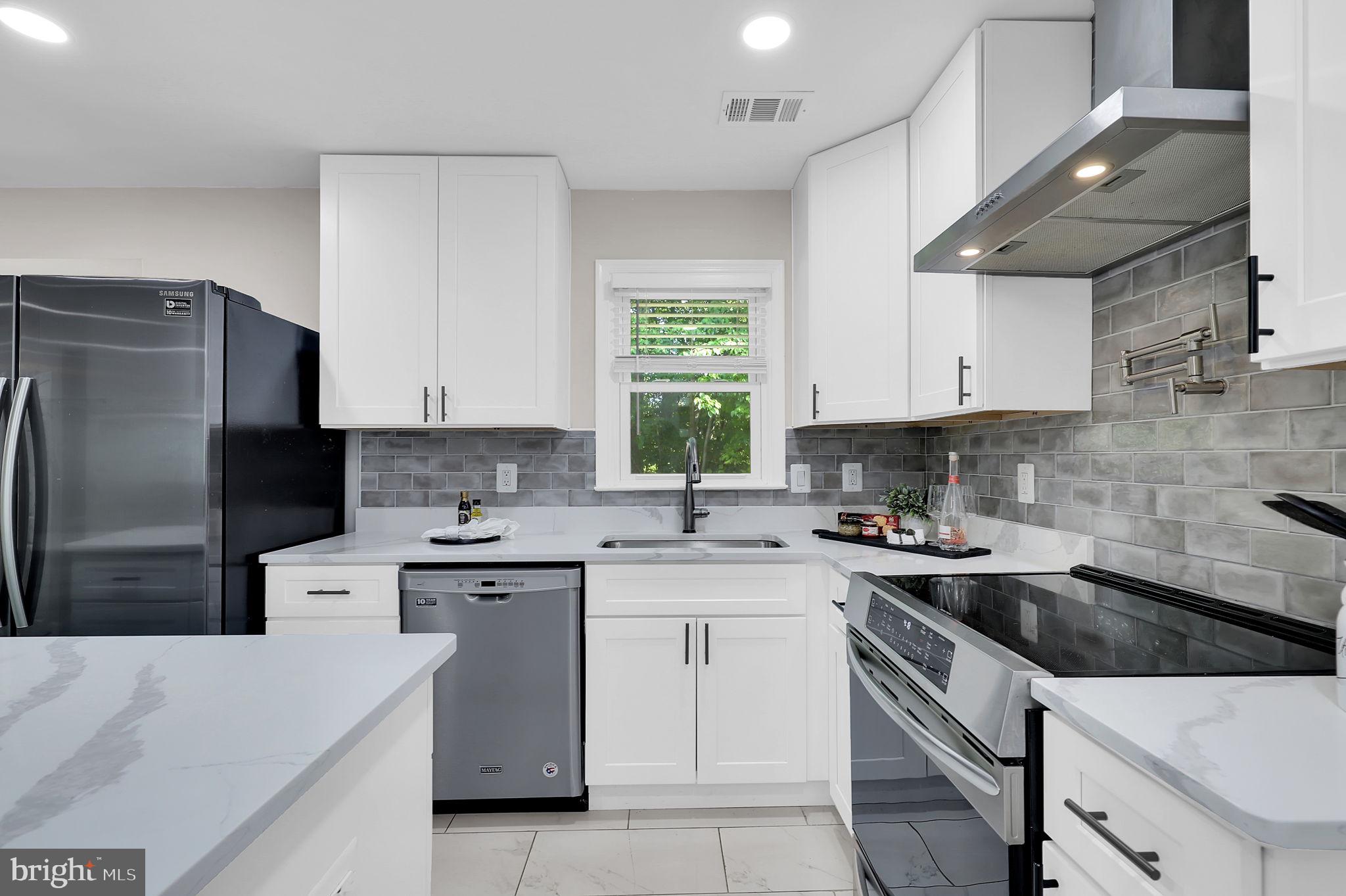 14901 Running Ridge Lane Silver Spring, MD 20906 - Photo 14 of 49 a kitchen with a sink a stove a refrigerator and cabinets