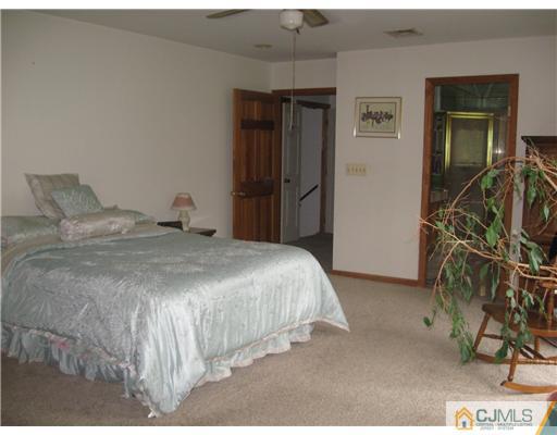 59 Henderson Road Kendall Park, NJ 08824 - Photo 4 of 12 a bedroom with a bed and a cabinets