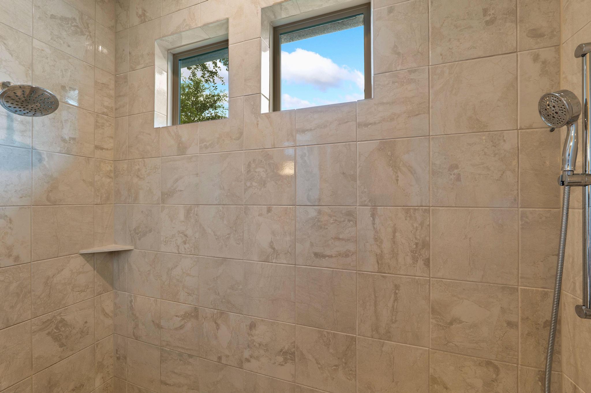 1009 Legacy Crossing Georgetown, TX 78628 - Photo 24 of 40 A well-lit shower with dual shower heads and a handy corner shelf.