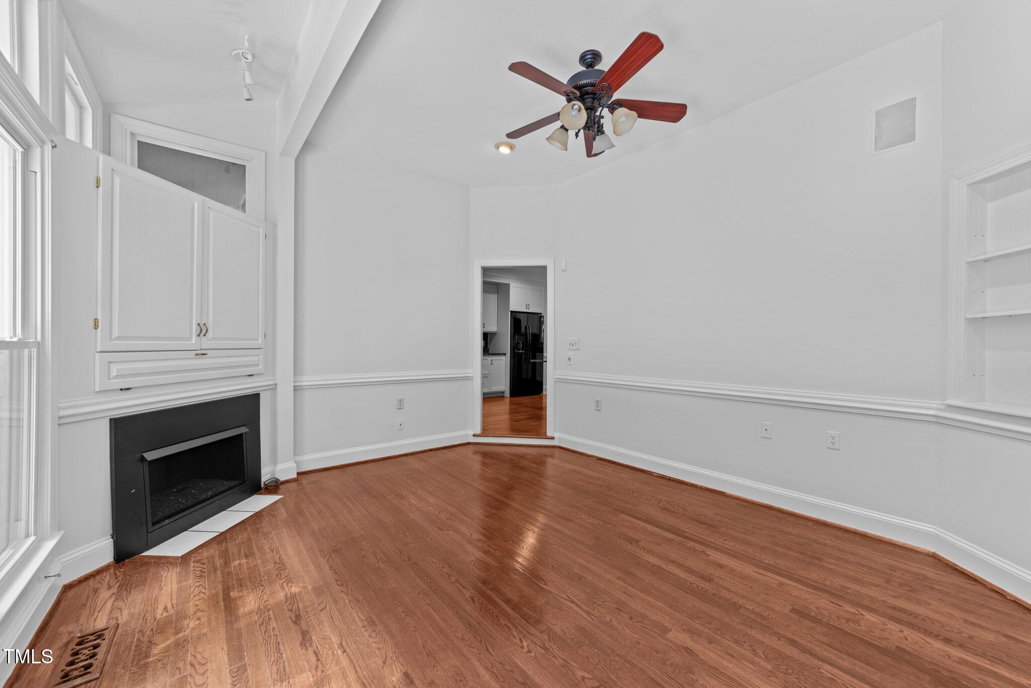11425 Horseman's Trail Raleigh, NC 27613 - Photo 18 of 64 a view of empty room with wooden floor and fireplace