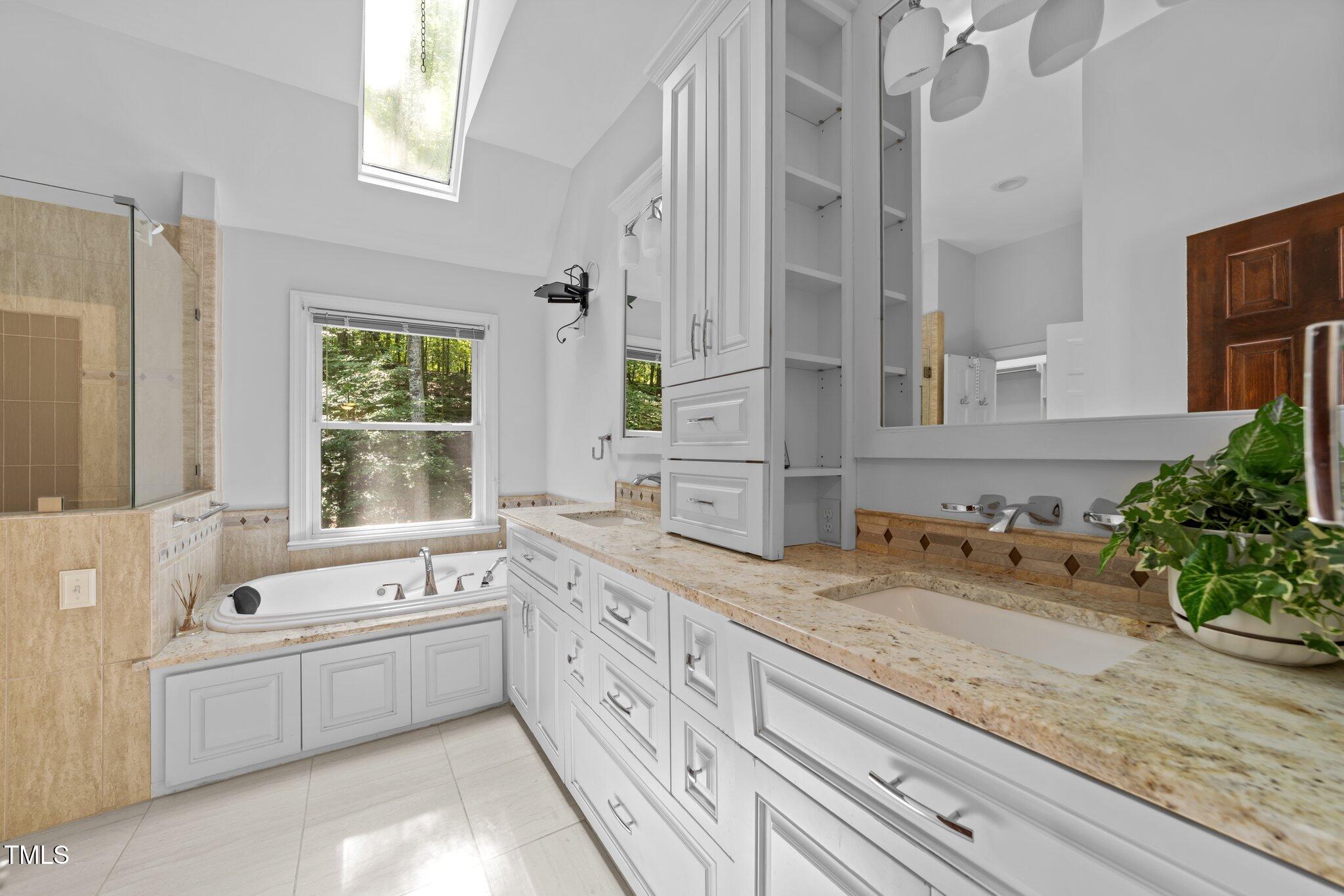 11425 Horseman's Trail Raleigh, NC 27613 - Photo 21 of 64 a bathroom with a granite countertop double vanity sink a mirror and a bathtub