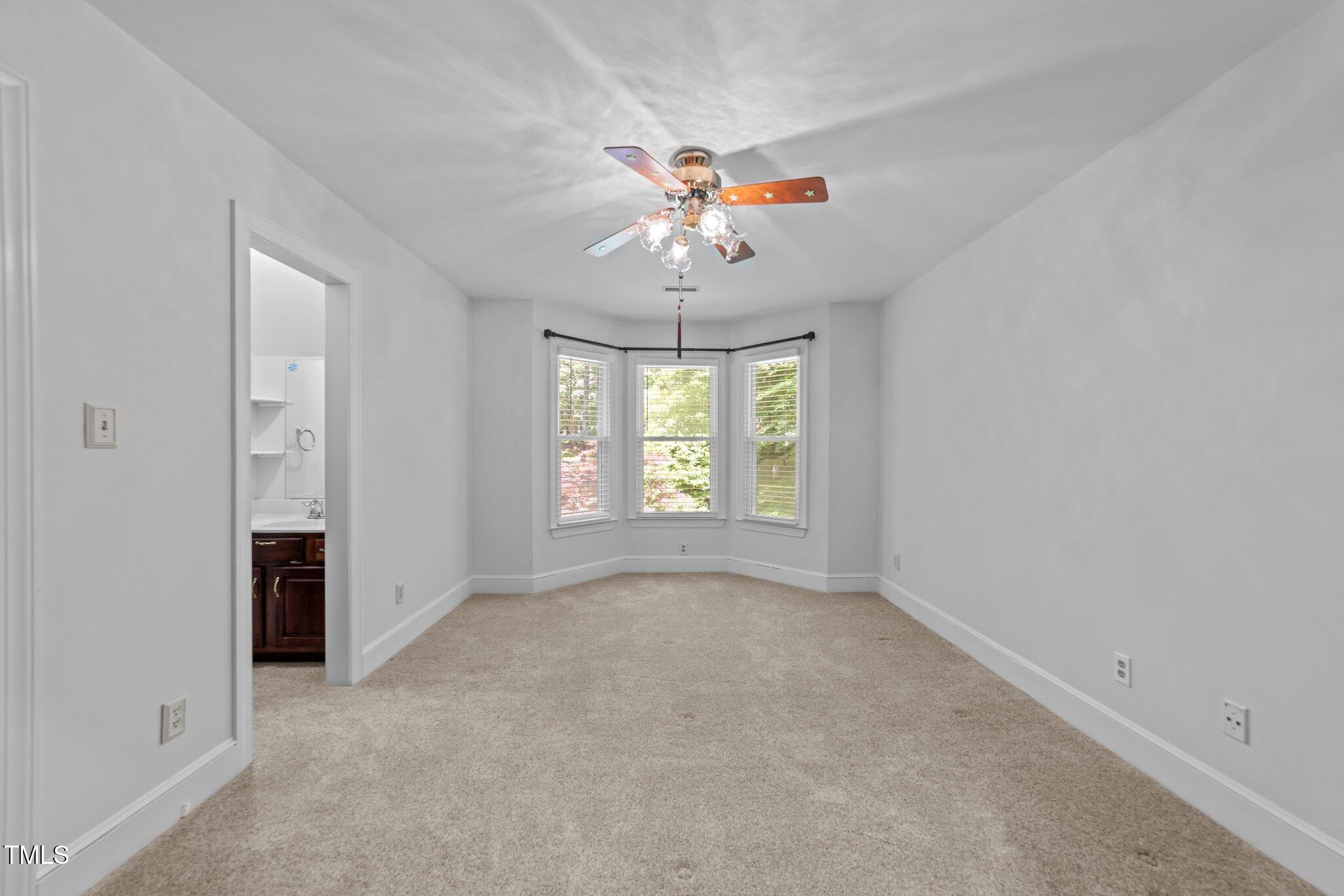 11425 Horseman's Trail Raleigh, NC 27613 - Photo 33 of 64 an empty room with chandelier fan and windows
