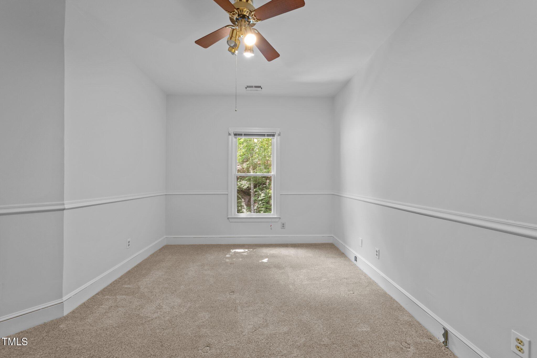 11425 Horseman's Trail Raleigh, NC 27613 - Photo 37 of 64 an empty room with a window and a fan
