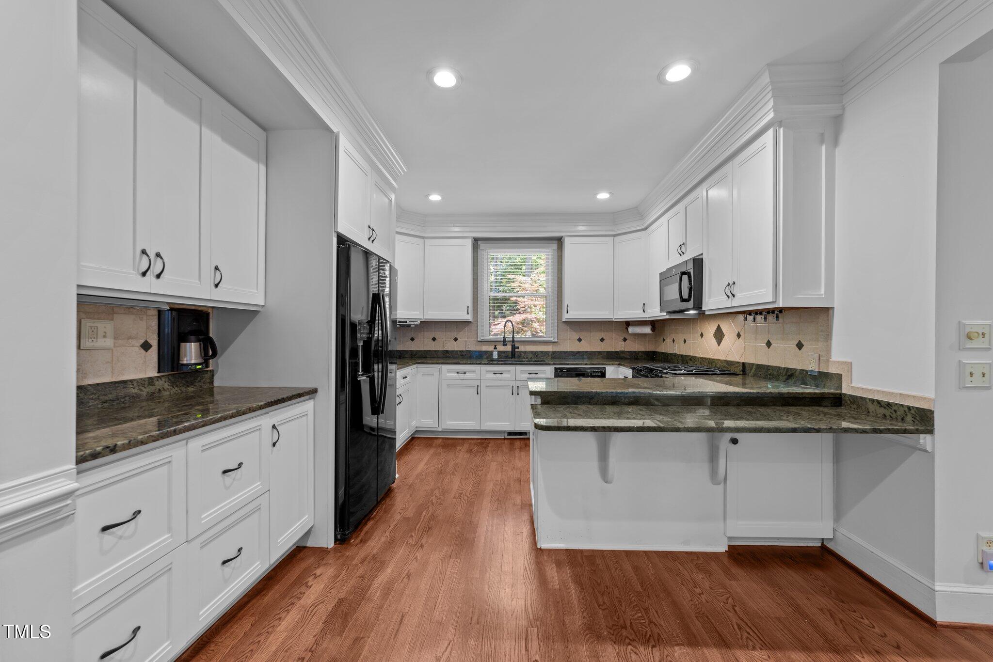 11425 Horseman's Trail Raleigh, NC 27613 - Photo 7 of 64 a kitchen with granite countertop white cabinets and white appliances