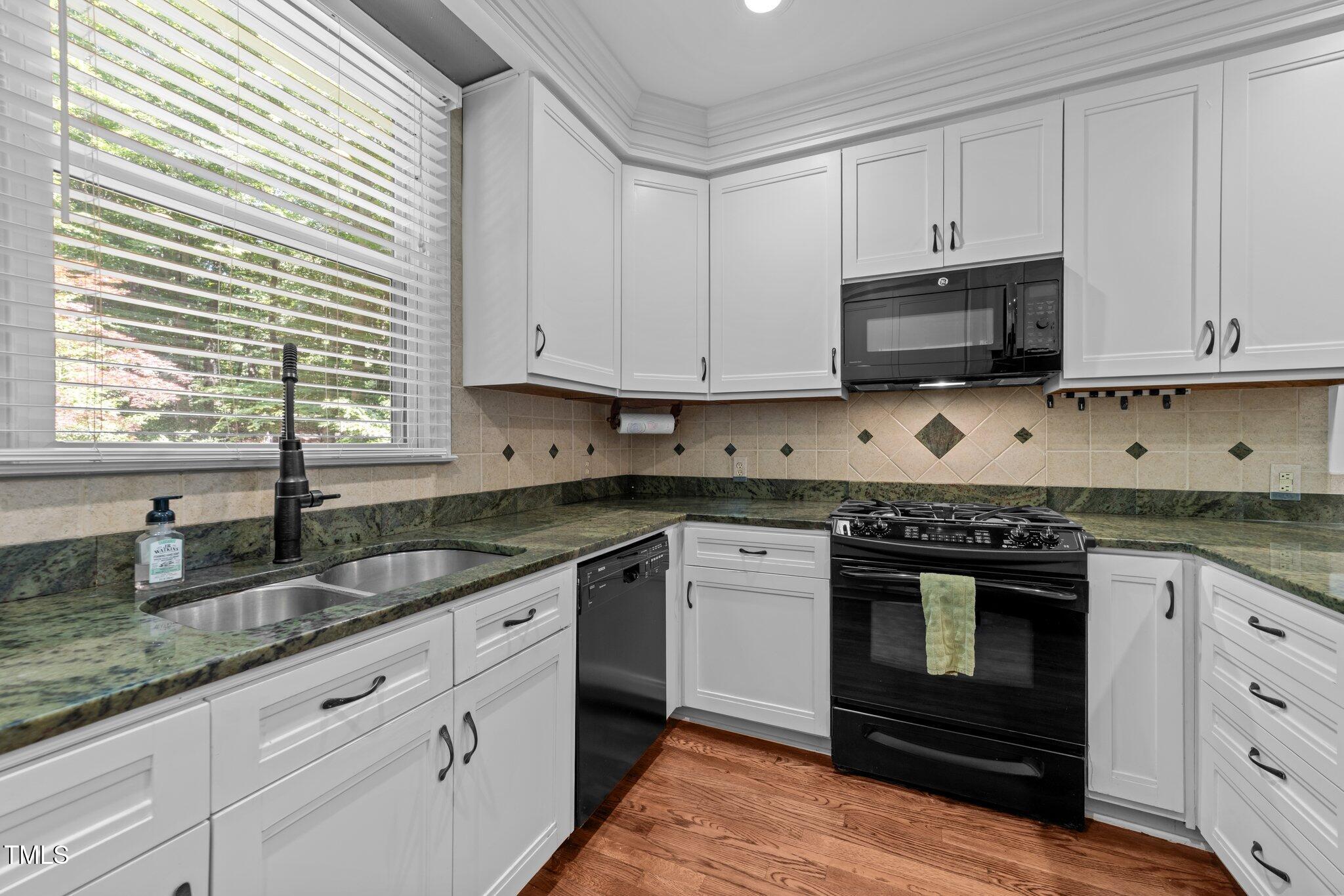 11425 Horseman's Trail Raleigh, NC 27613 - Photo 8 of 64 a kitchen with granite countertop white cabinets stainless steel appliances and a sink