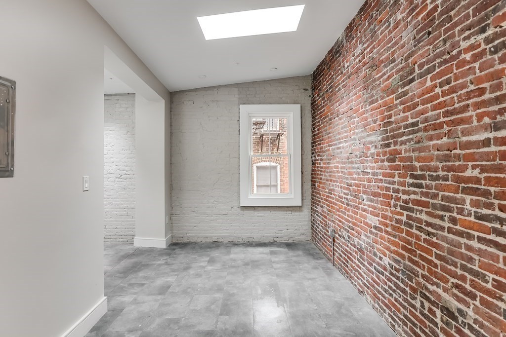 17 Sheafe Street, Unit 4 Boston, MA 02113 - Photo 2 of 6 a view of an empty room with brick wall and a window