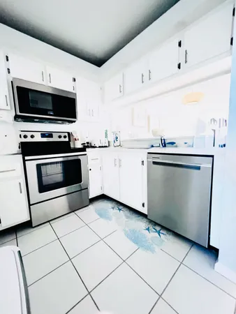 a kitchen with stainless steel appliances a stove a sink and a microwave