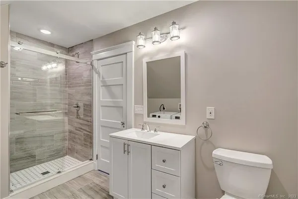 a bathroom with a toilet sink and mirror