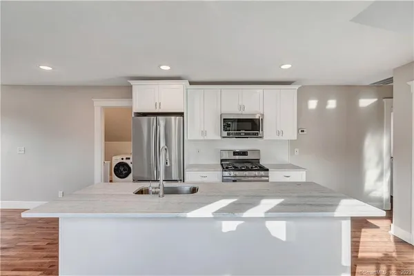 a kitchen with stainless steel appliances a sink stove and refrigerator