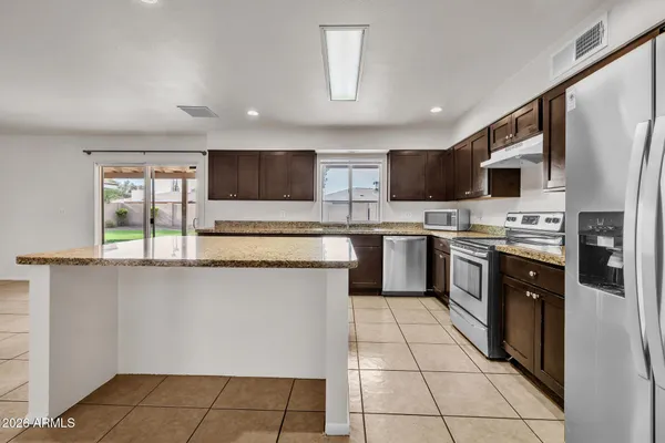 a kitchen with granite countertop a sink and cabinets