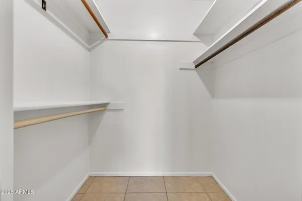 an empty room with chandelier fan and windows