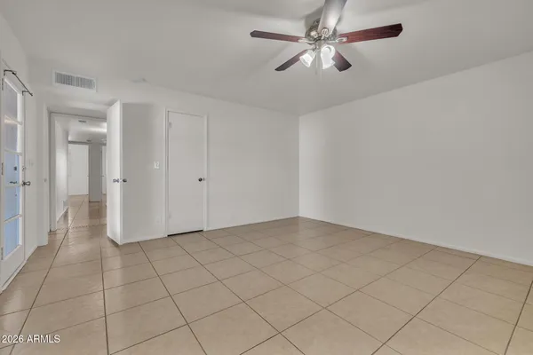 an empty room with windows and fan