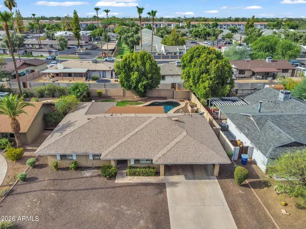 an aerial view of residential houses with outdoor space and parking