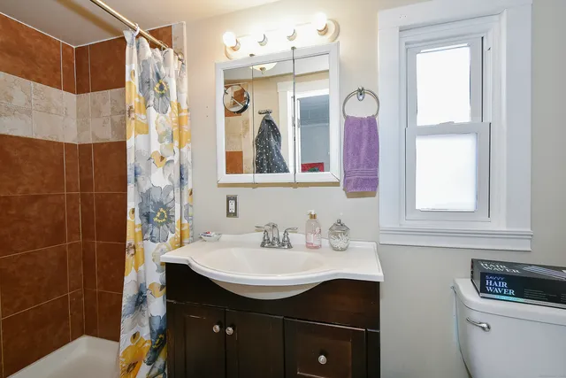 a bathroom with a granite countertop sink a mirror a vanity and a shower