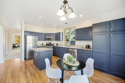 a kitchen with a dining table chairs and refrigerator