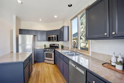 a kitchen with stainless steel appliances granite countertop refrigerator a sink a stove top oven and cabinets