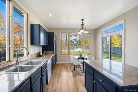 a kitchen with granite countertop a sink stove and cabinets