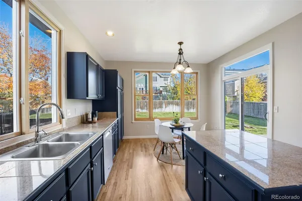 a kitchen with granite countertop a sink stove and cabinets