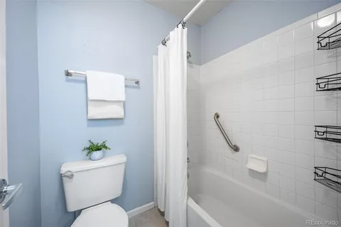 a white toilet sitting next to a bath tub