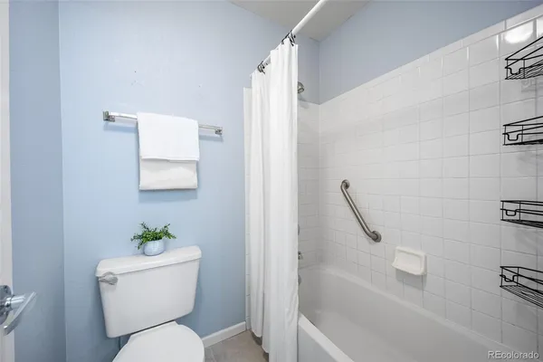 a white toilet sitting next to a bath tub