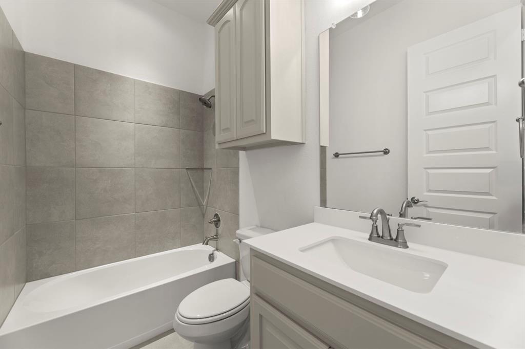 1442 Canadian Lane Van Alstyne, TX 75495 - Photo 20 of 27 a bathroom with a sink a toilet and bathtub