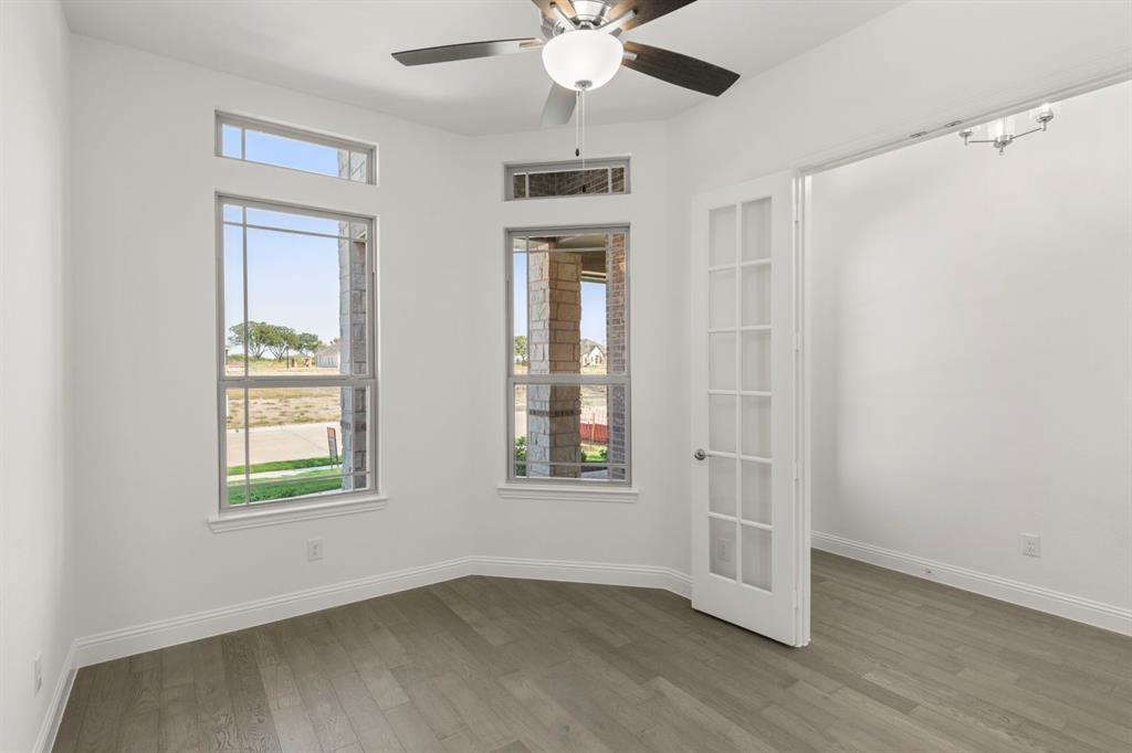 1442 Canadian Lane Van Alstyne, TX 75495 - Photo 4 of 27 an empty room with wooden floor chandelier and windows