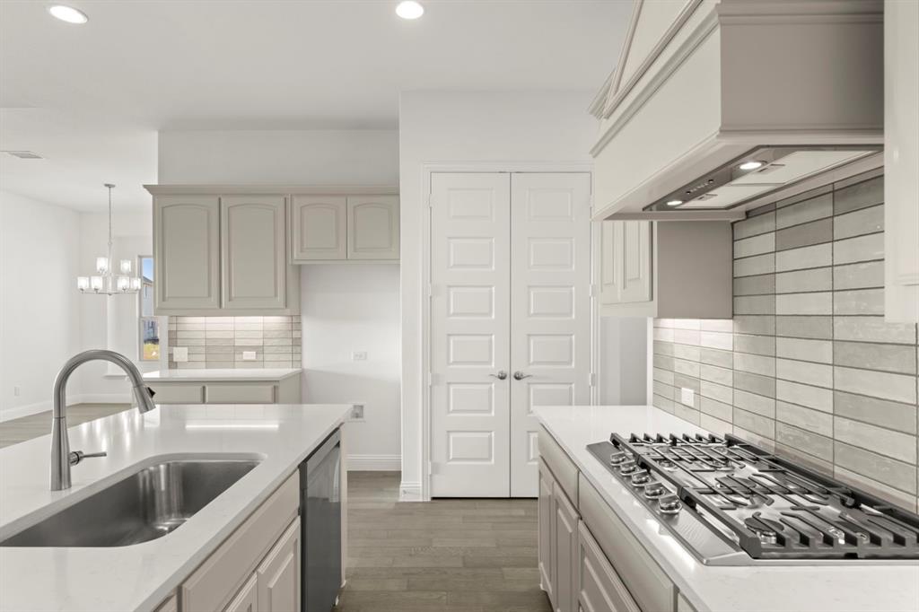 1442 Canadian Lane Van Alstyne, TX 75495 - Photo 7 of 27 a kitchen with white cabinets a sink stove and refrigerator