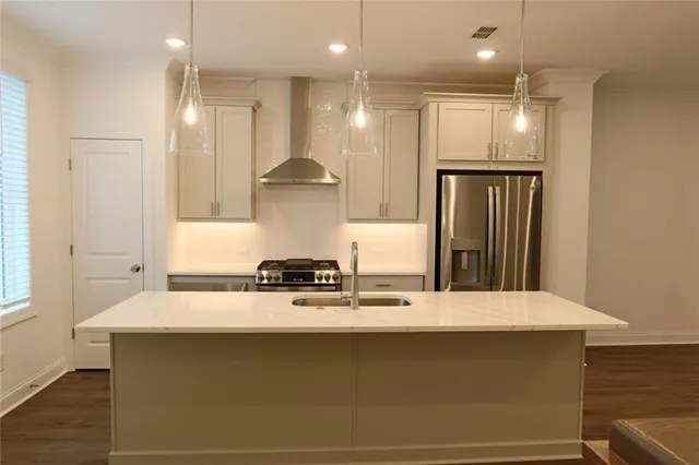 a large kitchen with stainless steel appliances a large counter top