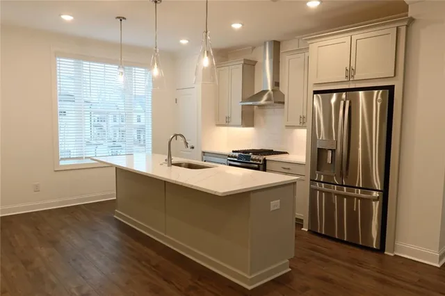 a kitchen with stainless steel appliances granite countertop a refrigerator a sink and a stove