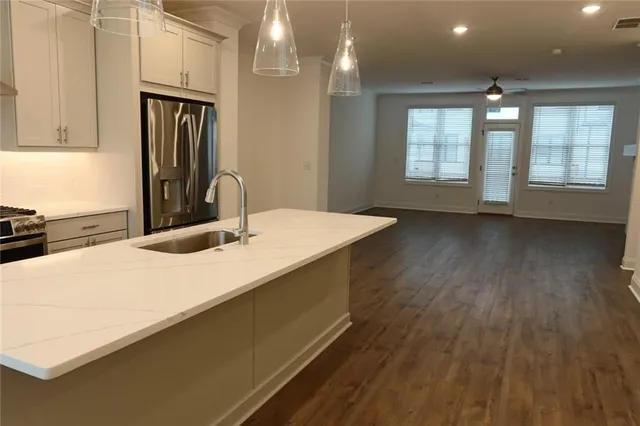 a kitchen with a sink a refrigerator and wooden floor