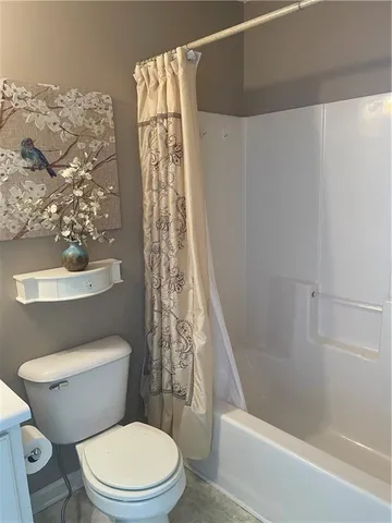 a white toilet sitting next to a shower curtain