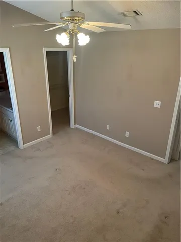 a view of an empty room with a chandelier fan
