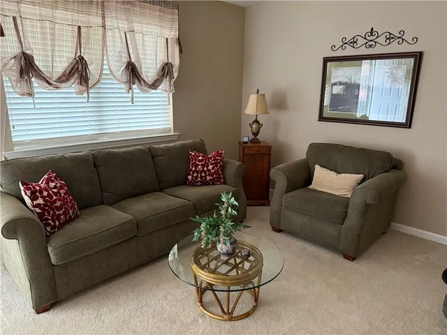 a living room with furniture a rug and a window