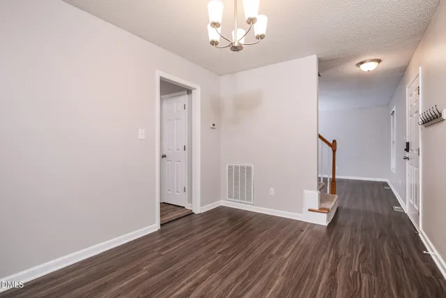 a view of empty room with wooden floor and ceiling fan