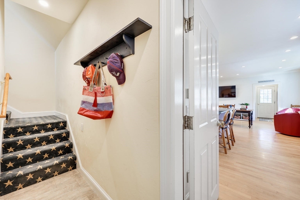 55 Cove Road Eastham, MA 02642 - Photo 40 of 42 a hallway with wooden floor and chandelier