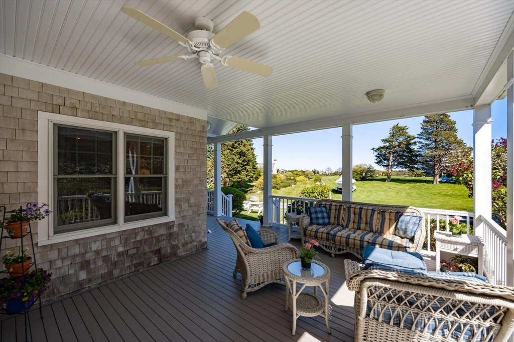 55 Cove Road Eastham, MA 02642 - Photo 8 of 42 a view of a patio with a table chairs and a floor to ceiling window